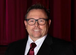 Man wearing business attire glasses smiling